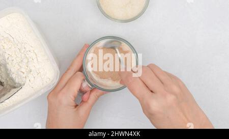 Ricetta per impasti di pane. Mescolare il lievito secco e lo zucchero nel latte caldo, cottura graduale, posa piatta Foto Stock