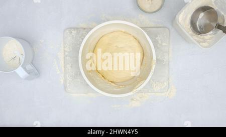 Impasto di pane rialzato in una ciotola, vista dall'alto. Passo dopo passo ricetta di pane al formaggio, processo di cottura Foto Stock