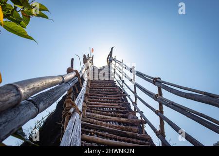 Le tradizionali scale di bambù che conducono al cielo blu luminoso dall'immagine ad angolo basso sono prese al Mawryngkhang Trek meghalaya india. Foto Stock