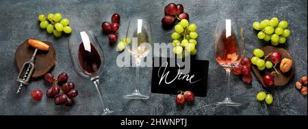Vino diverso in bicchieri su sfondo grigio. Drink estivo per feste, enoteca o degustazione di vini. Piatto, vista dall'alto, panorama Foto Stock