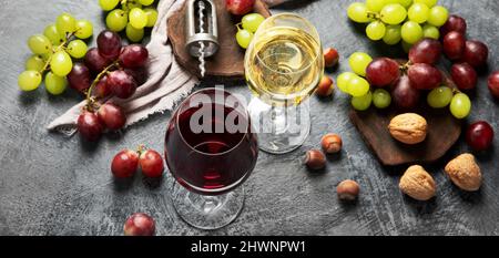 Vino diverso in bicchieri su sfondo grigio. Drink estivo per feste, enoteca o degustazione di vini. Panorama Foto Stock