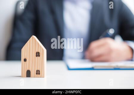 uomo che firma i documenti di contratto di casa. Contratto di contratto, immobiliare, acquisto e vendita e concetti assicurativi Foto Stock