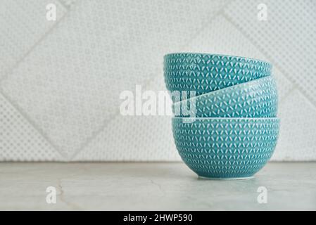 Tre ciotole vuote blu sul tavolo da cucina con spazio copia, vista frontale, interno cucina Foto Stock