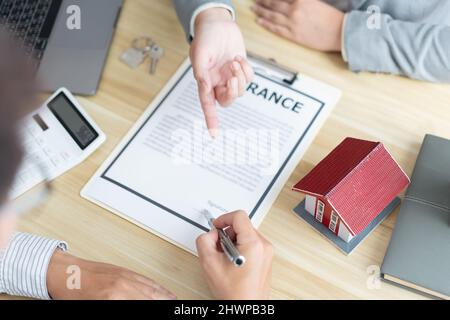 Concetto di assicurazione il mediatore che spiega l'accordo del contratto al suo cliente. Foto Stock
