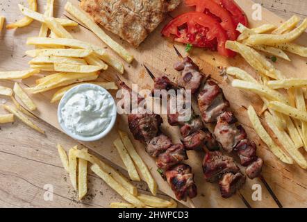 Piatto souvlaki, cibo di carne greca. Spiedini alla griglia e pita pane su tavola di legno, vista ravvicinata dall'alto, Foto Stock