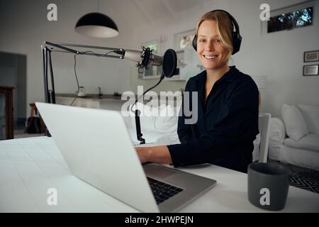 Serie di registrazione podcaster femminile caucasica da casa utilizzando il microfono Foto Stock