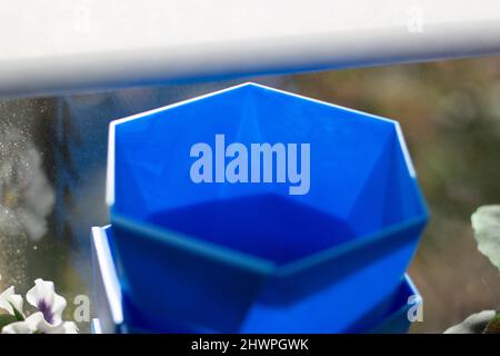 Vasi di fiori blu. Oggetto per pianta crescente. La luce solare cade sulla plastica blu. Dettagli sulle cose sul balcone. Foto Stock