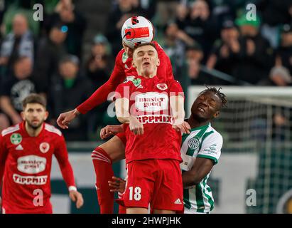 BUDAPEST, UNGHERIA - MARZO 6: Fortune Bassey di Ferencvarosi TC batte per la palla in aria con Bogdan Melnyk di Kisvarda Master Good #18 e Lazar Cirkovic di Kisvarda Master Good durante l'Ungherese OTP Bank Liga Match tra Ferencvarosi TC e Kisvarda Master Good al Groupama Arena il 6 marzo 2022 a Budapest, Ungheria. Foto Stock