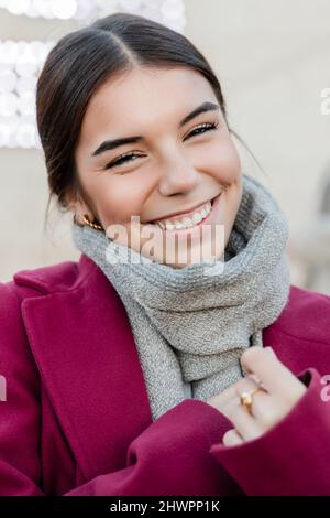 Sorridente giovane bella donna con sciarpa Foto Stock