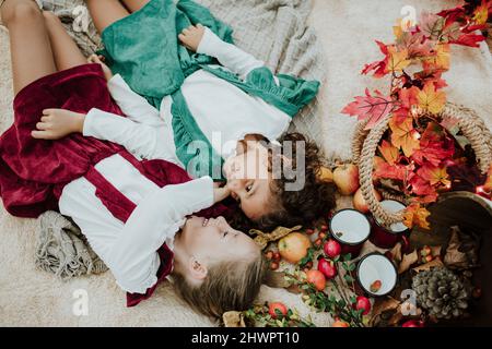 Ragazze sorridenti che giacciono sulla coperta da frutta al picnic nella foresta Foto Stock