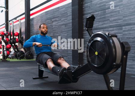 Atleta usando vogatore in palestra Foto Stock