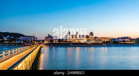 Germania, Mecklenburg-Vorpommern, Binz, molo vuoto al tramonto con Kurhaus Binz resort sfondo Foto Stock