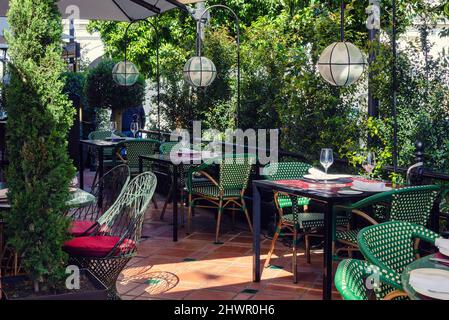 Terrazza esterna del ristorante vuota con piante naturali, tavoli e sedie. Giorno di sole. Foto Stock