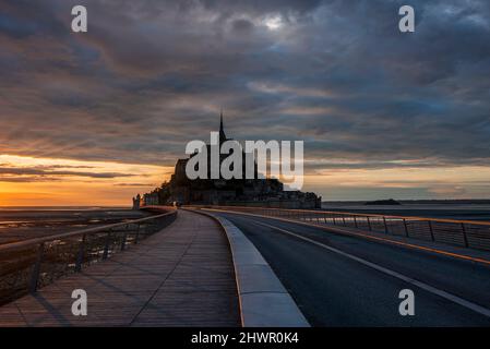 Francia, Normandia, cielo nuvoloso sul ponte che collega Mont-Saint-Michel isola al crepuscolo Foto Stock