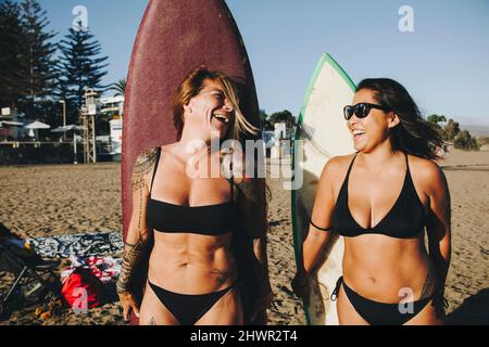 Buone donne in bikini con tavole da surf in spiaggia, Gran Canaria, Isole Canarie Foto Stock