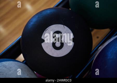 Usato palle di vari colori per giocare un gioco di bowling con fuoco nel numero nero 8. Foto Stock