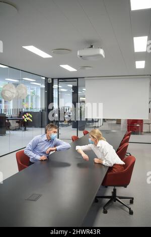 Uomo d'affari che fa il gomito bussare con il collega in ufficio Foto Stock