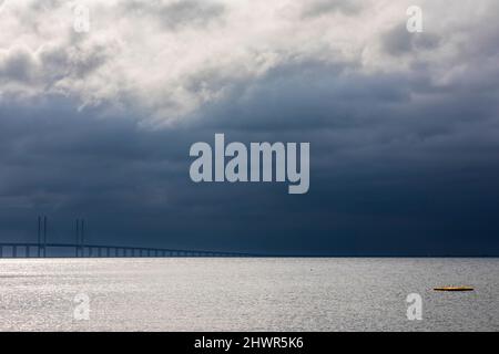 Cielo nuvoloso sopra Sound stretto con la silhouette del ponte Oresund sullo sfondo Foto Stock