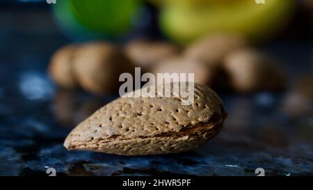 Noccioli di albicocche, mandorle sgusciate. Le mandorle sgusciate si avvicinano a macro shot. La messa a fuoco è nella parte anteriore. Effetto bokeh sul retro. Foto Stock