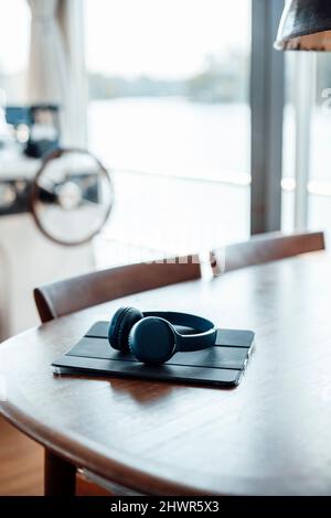 Tablet PC e cuffie wireless su tavolo in legno presso houseboat Foto Stock