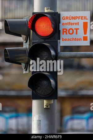 07 marzo 2022, Sassonia, Lipsia: Un nuovo segno 'freccia verde rimosso, obbedire rosso! Si trova sopra una freccia verde accanto a un semaforo rosso all'incrocio Adenauerallee/Rohrteichstraße. Per aumentare la sicurezza del traffico, nelle prossime settimane saranno rimosse 24 frecce verdi dai semafori di Lipsia. Negli ultimi tre anni vi sono stati diversi incidenti tra le auto che si accerteranno di rosso e che attraversano pedoni e ciclisti. Alcune delle persone coinvolte sono state gravemente ferite. Foto: Jan Woitas/dpa-Zentralbild/ZB Foto Stock