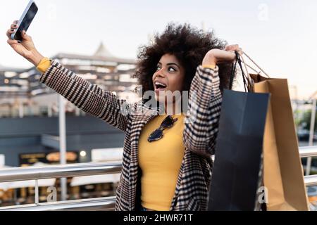 Donna felice con borse shopping prendere selfie su smartphone Foto Stock