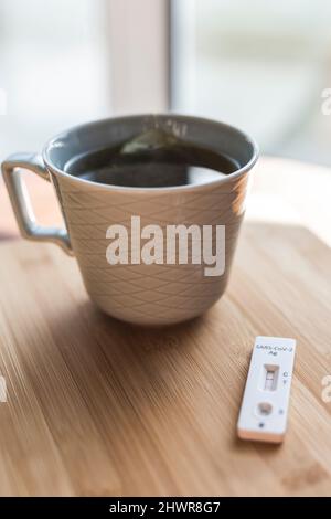 Tazza di tè e test diagnostico rapido per COVID-19 Foto Stock