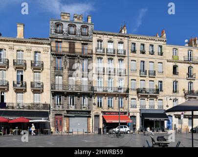 Un gruppo di case sul lato ovest dello spazio aperto intorno alla Basilica di San Michel, a Bordeaux, una di esse non pulita di macchie di fumo. Foto Stock