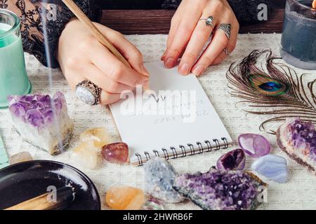 Vista dall'alto delle mani della donna fare matematica, calcolare il numero del percorso di vita sulla carta in casa. Il risultato è 11. Concetto di numerologia spirituale. Foto Stock