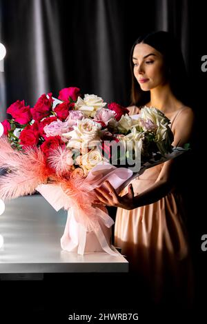 La ragazza tiene un grande bouquet di fiori rosa e bianchi. Foto Stock