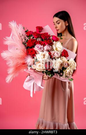 La ragazza tiene un grande bouquet di fiori rosa e bianchi. Foto Stock