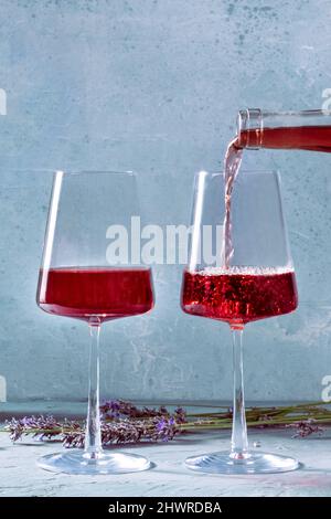 Due bicchieri di vino rosato con un posto per il testo e un mazzo di fiori di lavanda, i vini della Provenza Foto Stock