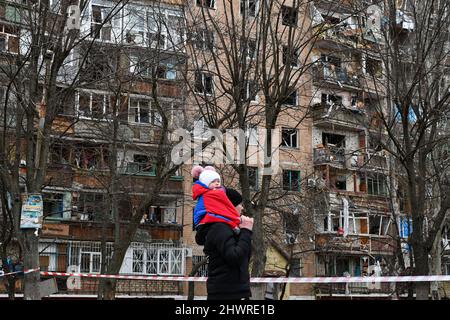 Kramatorsk, Ucraina. 06th Mar 2022. Un uomo con un bambino ha visto guardare un edificio danneggiato a Kramatorsk. L'invasione russa dell'Ucraina è entrata nel suo giorno successivo, con alcuni esperti che suggeriscono che l'invasione potrebbe essersi bloccata in luoghi - nonostante l'insistenza del Presidente Vladimir Putin sabato che l'operazione "sta per pianificare". Credit: SOPA Images Limited/Alamy Live News Foto Stock