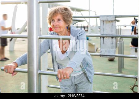 Una donna anziana si allena all'aperto Foto Stock