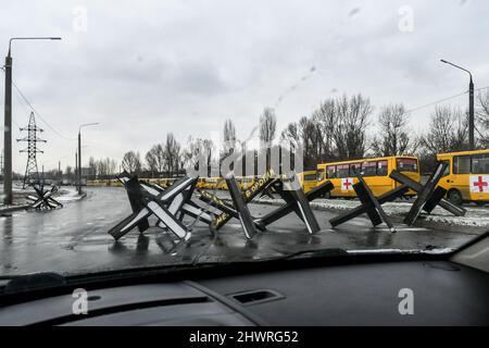 ZAPORIZHZHIA, UCRAINA - 6 MARZO 2022 - ostacoli anticarro, noti come hedgehog cechi, bloccano una strada vicino a un convoglio di autobus pronti a decollo per assediata Mariupol per fornire aiuti umanitari e evacuare la gente se il corridoio verde è confermato, Zaporizhzhzia, Ucraina sudorientale. Foto di Smoliyenko Dmytro/Ukrinform/ABACAPRESS.COM Foto Stock