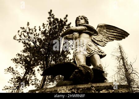 San Michele sconfigge Satana. Sculture del parco nella zona del lago di Annecy. Duingt, Francia. Il buon trionfo sul concetto del male. Foto storica di Seppia Foto Stock