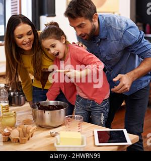 Questo sembra così yummy. Shot di una famiglia felice che cuoce insieme in cucina. Foto Stock