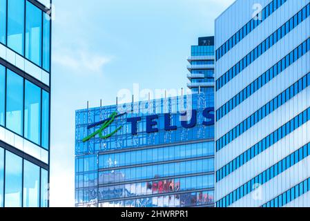 Toronto, Canada - 7 marzo 2022: Logo o segno della società di telecomunicazioni Telus in cima a un edificio moderno nel quartiere del centro Foto Stock