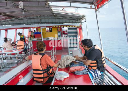 Vista posteriore dei passeggeri amanti in giubbotto di vita rilassante sul balcone che gode di vista dalla barca dell'isola di Samui in SEA.Happy coppia turisti casual fuori su Foto Stock