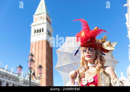 Donna in un bel costume tradizionale veneziano e maschera posata al carnevale di Venezia. St Piazza Marco, Venezia Foto Stock