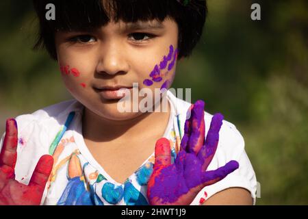 Tema Holi colorato - Ritratto di carino indiano Kid dipinto in polvere Holi colore chiamato Rang Gulal Aber o Abir Foto Stock