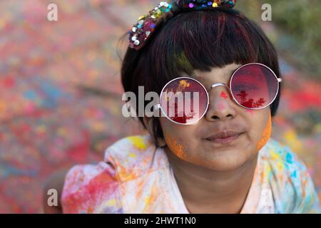 Tema Holi colorato - Ritratto di carino indiano indossando tondi colori e dipinti in polvere di colore Holi chiamato Rang Gulal Aber o Abir Foto Stock