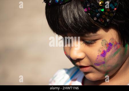 Tema Holi colorato - Ritratto di carino indiano indossando tondi colori e dipinti in polvere di colore Holi chiamato Rang Gulal Aber o Abir Foto Stock