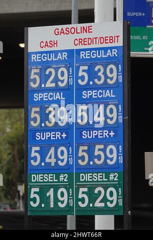 Un cartello della stazione di servizio visualizza i prezzi correnti del carburante a oltre $5 USD per gallone vicino ad una strada negli Stati Uniti, durante il giorno in una vista verticale. Foto Stock