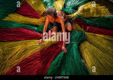 Vietnamita vecchio artigiano asciugando tradizionale vietnam stuoie nel vecchio villaggio tradizionale a dinh Yen, dong thap, vietnam, tradizione artista concetto, Foto Stock