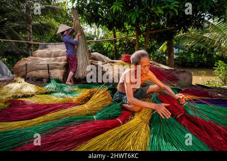 Vietnamita vecchio artigiano asciugando tradizionale vietnam stuoie nel vecchio villaggio tradizionale a dinh Yen, dong thap, vietnam, tradizione artista concetto, Foto Stock