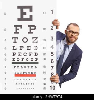 Giovane uomo con occhiali che sbucciano da dietro un pannello di esame visivo isolato su sfondo bianco Foto Stock