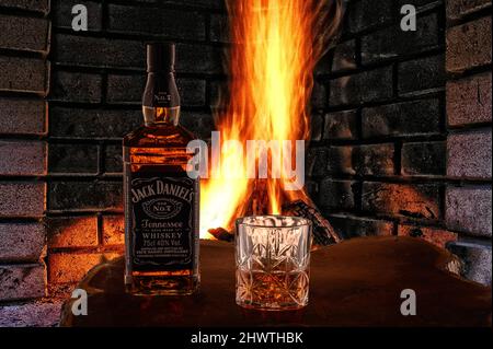 Puerto Plata, repubblica Dominicana, 2.02.2022. Vista DI JACK DANIELS TENNESSEE WHISKEY in bottiglia e bicchiere DI WHISKEY con ghiaccio di fronte al fuoco in fiamme Foto Stock
