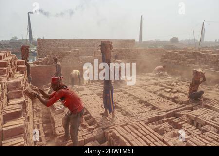 Keraniganj, Bangladesh. 07th Mar 2022. Gli uomini del Bangladesh lavorano in un campo di mattoni a Keraniganj, vicino a Dhaka, Bangladesh, 7 marzo 2022. L'emissione di un'enorme quantità di elementi tossici da forni in mattoni sta causando gravi rischi per la salute ai lavoratori e alle persone che vivono nelle aree circostanti con la maggior parte che soffrono di problemi respiratori o cutanei. I lavoratori in questo campo mattone guadagnano meno di $5 al giorno. (Foto di Suvra Kanti Das/Sipa USA) Credit: Sipa USA/Alamy Live News Foto Stock