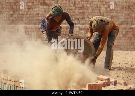 Keraniganj, Bangladesh. 07th Mar 2022. Gli uomini del Bangladesh lavorano in un campo di mattoni a Keraniganj, vicino a Dhaka, Bangladesh, 7 marzo 2022. L'emissione di un'enorme quantità di elementi tossici da forni in mattoni sta causando gravi rischi per la salute ai lavoratori e alle persone che vivono nelle aree circostanti con la maggior parte che soffrono di problemi respiratori o cutanei. I lavoratori in questo campo mattone guadagnano meno di $5 al giorno. (Foto di Suvra Kanti Das/Sipa USA) Credit: Sipa USA/Alamy Live News Foto Stock